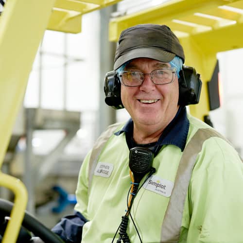 Picture of J.R. Simplot Company Australian employee in safety gear driving forklift in warehouse.
