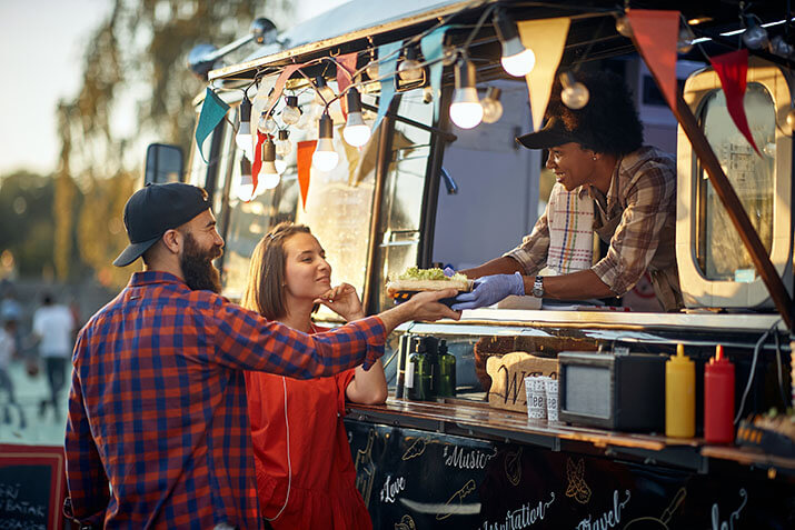 Happy customers receive their order from a food truck