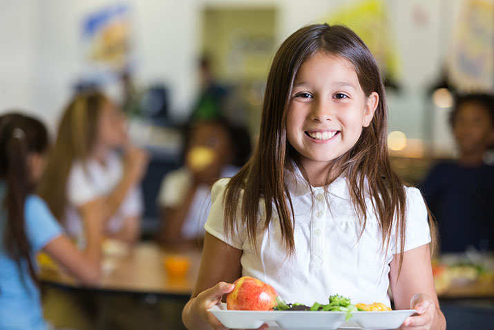 K-12 student holding lunch tray