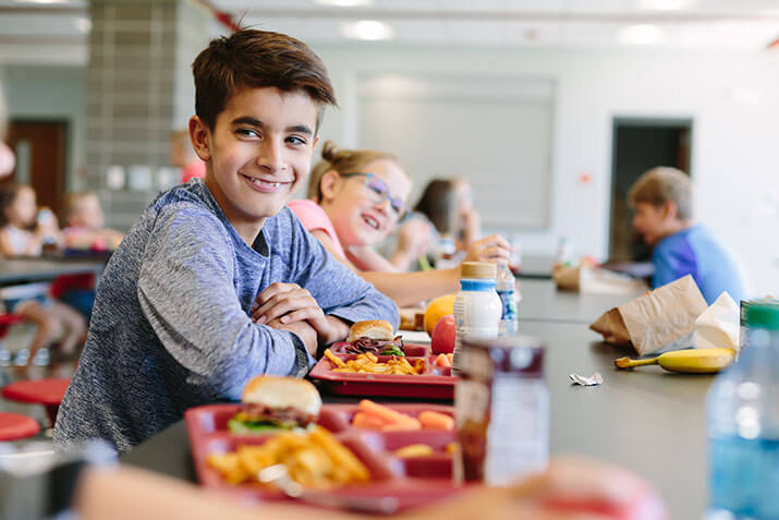 K-12 students having lunch in cafeteria