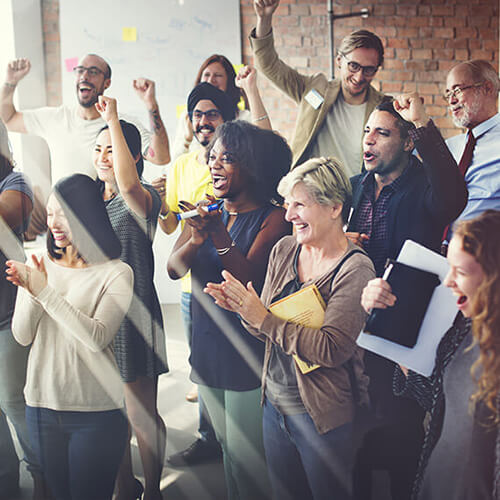 Image of a diverse group of adults in a casual office setting celebrating employee engagement and inclusion together.