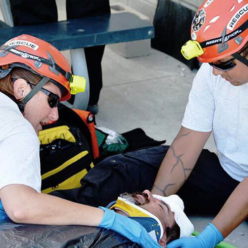 Picture of two Simplot search and rescue team volunteers caring for a victim during mock mass casualty exercise.