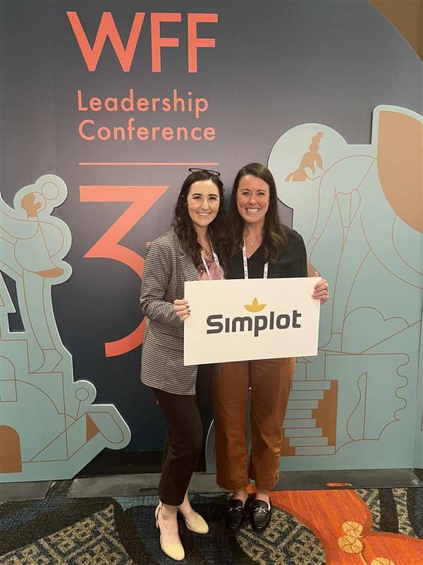 Two women holding a Simplot sign at the 2024 WWF Conference