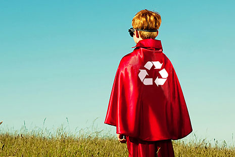Young boy with a red cape with a recycle symbol