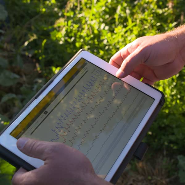 Man holding tablet showing data in a farm field