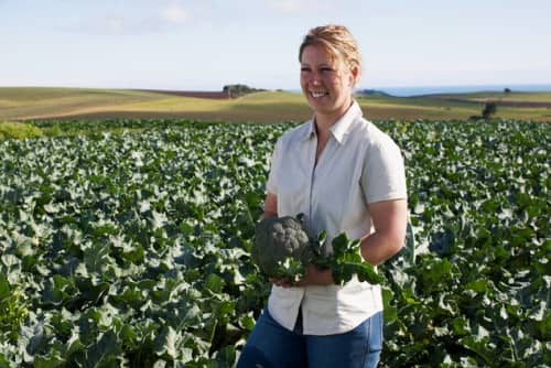 Female Farmer in field holding Broccoli